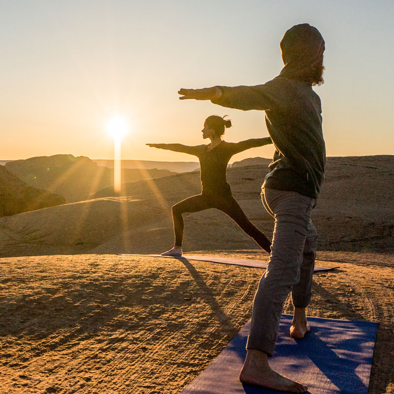 Good Living Health two persons doing yoga on hilltop